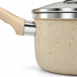 Close-up of a speckled beige nonstick saucepan with a light wood handle and stainless steel rim, shown on a white background.
