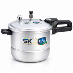 A silver aluminum pressure cooker with black handles and lids, featuring SK Cookware and The First Choice logos on the front, set against a plain white background.