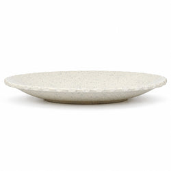 A round ceramic plate with a textured, speckled off-white glaze and a flared rim, photographed on a seamless white background.